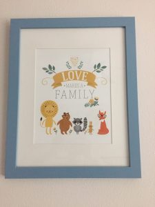Framed print on the wall that says "Love Makes a Family."