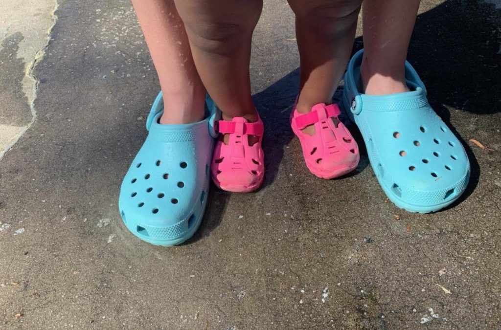 mom and baby in matching pink and blue crocs shoes