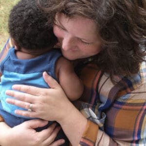 white mom hugs a african american infant child.