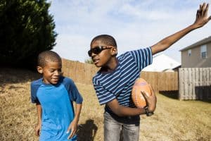 two boys pose with a football.