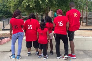Group of kids wearing t-shirts with "16" on the back