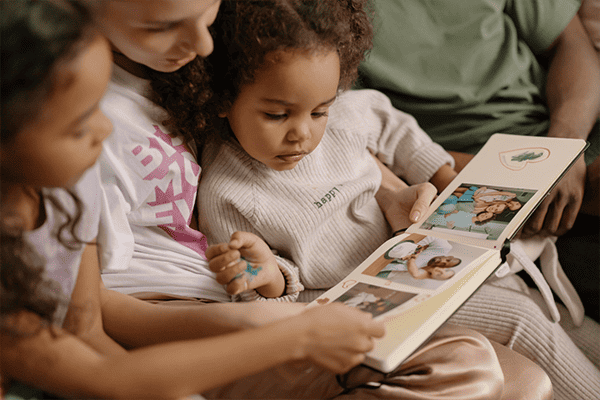 Young girl with mom reading book to her