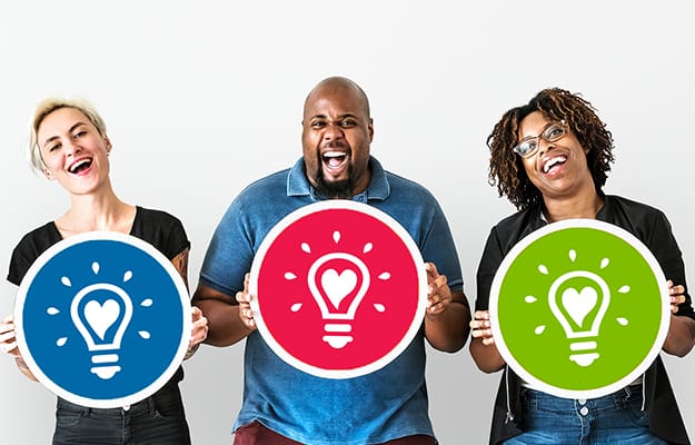 Group of diverse people holding Fostering Great Ideas light bulb logo