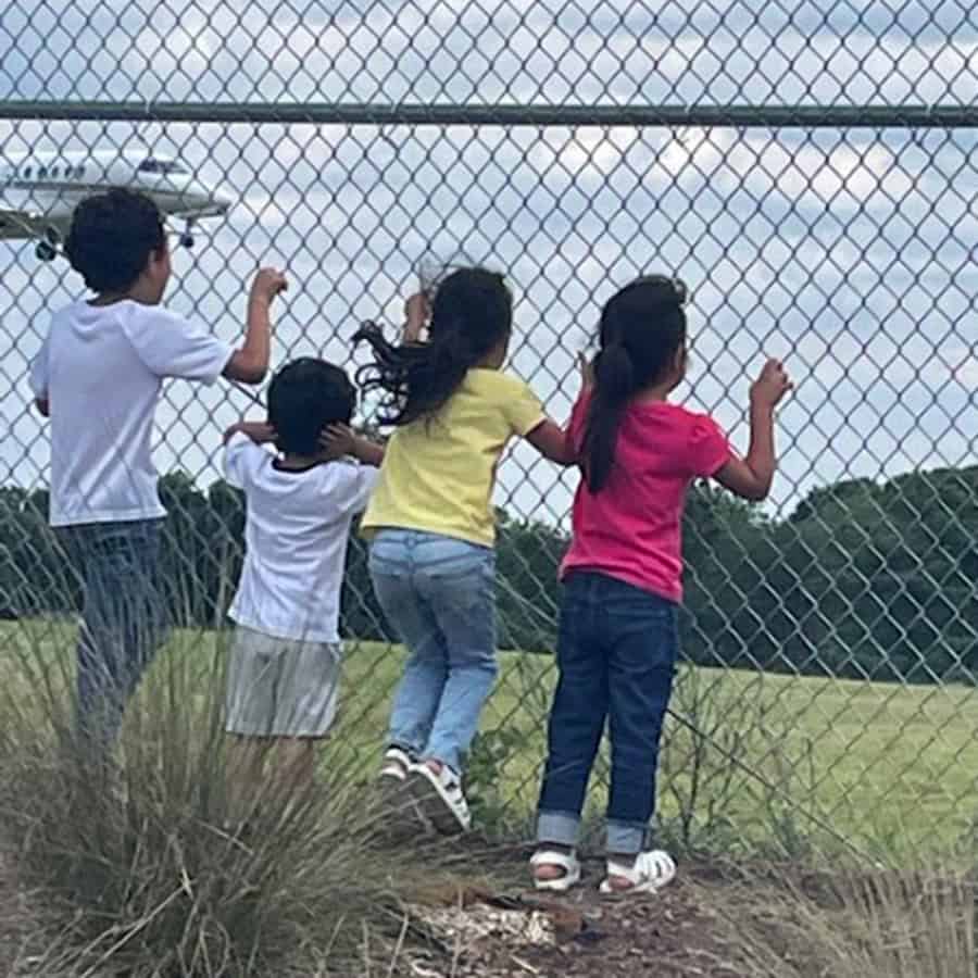 Group of siblings watching a plane fly in